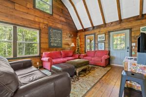 a living room with red furniture and a chalkboard at Knotty By Nature- Pet Friendly, Firepit, 150 Acres in Campton