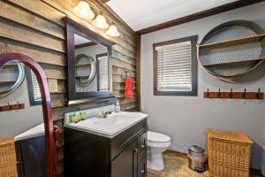 a bathroom with a sink and a toilet and mirrors at Knotty By Nature- Pet Friendly, Firepit, 150 Acres in Campton +36 photos