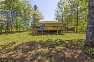 a house in the middle of a field with trees at Knotty By Nature- Pet Friendly, Firepit, 150 Acres in Campton