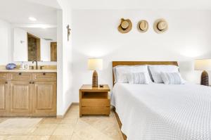 a white bedroom with a bed and a sink at The OceanFront Private Residence in La Paz