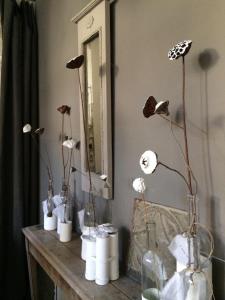 a bunch of flowers in vases on a table in front of a mirror at La maison sur la place in Penne-dʼAgenais +61 photos