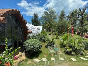 a garden with chairs and plants in a yard at Mũi Si Homestay Cửa Tùng in Vĩnh Bang
