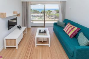 a living room with a blue couch and a table at Alfagar Prestige in Albufeira