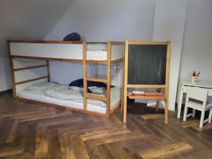 two bunk beds in a room with a table at Chata Kolmanovci in Oščadnica