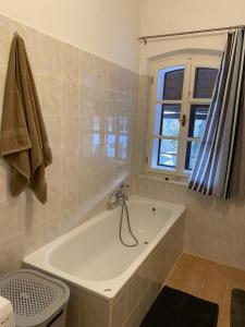 a white bath tub in a bathroom with a window at Apartmán Na Pavlači in Velký Třebešov +3 photos