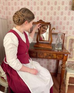 a woman is looking at her reflection in a mirror at Lang Resort in Raahe