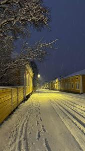 a snow covered street at night with a street light at Lang Resort in Raahe