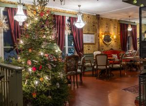 a room with a christmas tree and a dining room at Lang Resort in Raahe