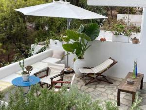 a patio with a couch and a table and an umbrella at Charming Spetses Studio with Outdoor Space in Spetses