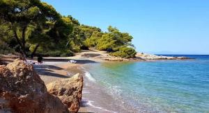 a beach with rocks and the water and trees at Charming Spetses Studio with Outdoor Space in Spetses +2 photos