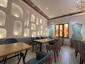 a restaurant with tables and chairs and a wall with mirrors at AYUB Modern & Heritage HOTEL in Bukhara