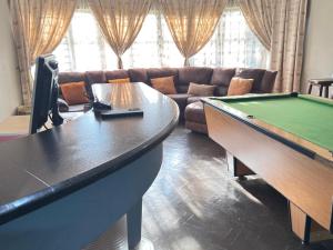 a living room with a pool table and a couch at Palm Guesthouse in Zeerust