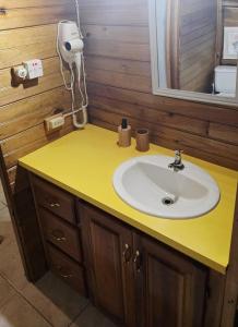 a bathroom with a sink and a yellow counter at Negril Humble Cabin in Negril +43 photos