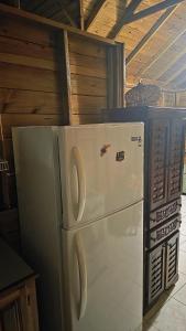 a white refrigerator freezer sitting in a kitchen at Negril Humble Cabin in Negril