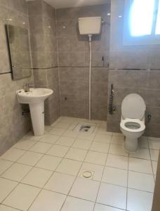 a bathroom with a toilet and a sink at شقق أبهى المضياف الذهبية للشقق المخدومة in Abha +14 photos