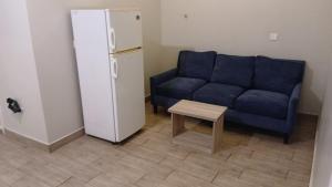 a living room with a couch and a table and a refrigerator at شقق أبهى المضياف الذهبية للشقق المخدومة in Abha