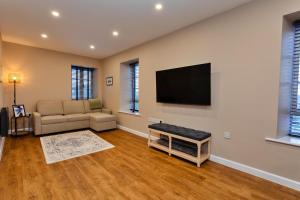 a living room with a couch and a flat screen tv at Finest Retreats - The Kiln in Bamburgh