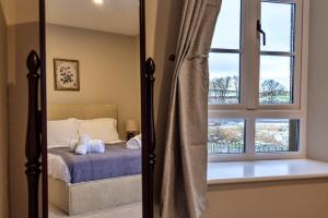 a bedroom with a bed and a window at Finest Retreats - The Kiln in Bamburgh