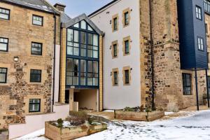 an old building with snow in front of it at Finest Retreats - The Kiln in Bamburgh