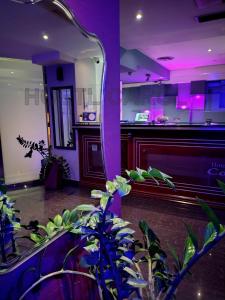a mirror in a room with plants and a piano at Carol Hotel in Piraeus