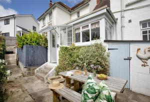 a small backyard with a wooden table in front of a house at Withycombe in Seaton