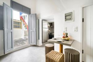 a kitchen with a table and chairs and an open door at Mykonos Yialos Town Home Loft - by Hospirit in Mikonos