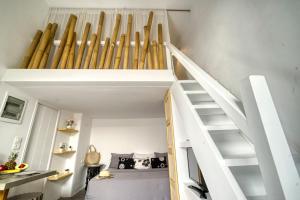 a room with a white staircase with baseball bats at Mykonos Yialos Town Home Loft - by Hospirit in Mikonos