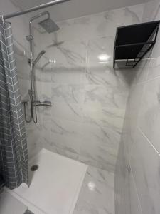 a bathroom with a shower with a television on the wall at Paris visite in Ivry-sur-Seine +3 photos