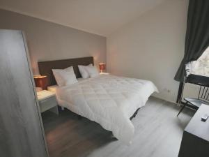 a bedroom with a bed with a white comforter at Aquaronde 125 in Lemmer
