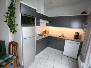 a kitchen with black cabinets and a white refrigerator at Aquaronde 129 in Lemmer