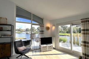 a living room with a large sliding glass door with a television at Aquaronde 122 in Lemmer