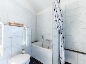 a white bathroom with a toilet and a bath tub at Aquaronde 117 in Lemmer +18 photos