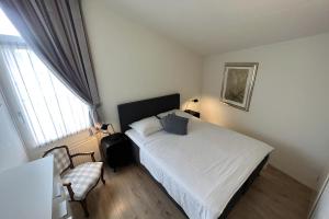 a bedroom with a bed and a chair and a window at Aquaronde 120 in Lemmer
