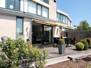 a house with a wooden deck with chairs and plants at Park Brekkense Wiel 058 in Lemmer