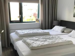 two twin beds in a room with a window at Park Brekkense Wiel 058 in Lemmer