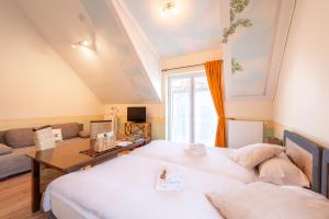 a bedroom with two beds and a living room at SCHUSTERjunge Aparthotel I Zentral I Studio Apartments I Küche & Bad I Parkplatz in Sasbachwalden
