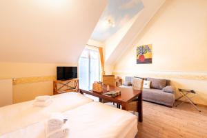a hotel room with a bed and a living room at SCHUSTERjunge Aparthotel I Zentral I Studio Apartments I Küche & Bad I Parkplatz in Sasbachwalden