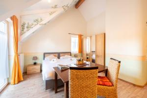 a bedroom with a bed and a table and chairs at SCHUSTERjunge Aparthotel I Zentral I Studio Apartments I Küche & Bad I Parkplatz in Sasbachwalden