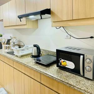 a microwave sitting on a counter in a kitchen at Celeste Stays- Celandine in Sampong