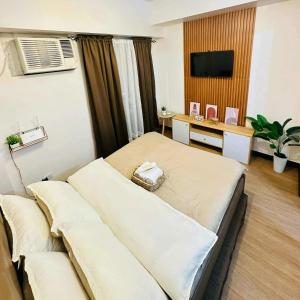 a bedroom with a bed and a desk with a television at Celeste Stays- Celandine in Sampong
