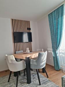 a dining room with a wooden table and chairs at Vikvid in Kopaonik