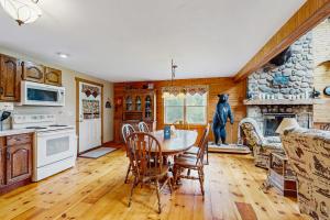 a kitchen with a table and a stone fireplace at Chez Normand in Jefferson