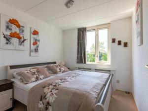 a bedroom with a bed and a window at Park Brekkense Wiel 069 in Lemmer