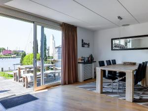 a living room with a table and a large window at Park Brekkense Wiel 069 in Lemmer +6 photos