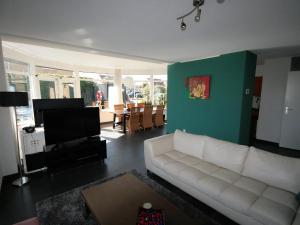 a living room with a white couch and a green wall at Park De Markol Leeuwerik 12 in Lemmer
