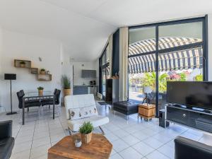 a living room with a tv and a couch and a table at Aquaronde 050 in Lemmer