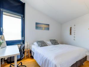 a bedroom with a bed and a desk and a window at Aquaronde 050 in Lemmer