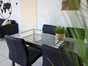 a glass dining table with chairs and a potted plant at Aquaronde 050 in Lemmer