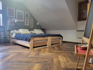 a bedroom with a bed with blue sheets and wooden floors at Chata Kolmanovci in Oščadnica