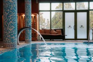 a swimming pool with a couch in a hotel lobby at SPA Hotel Olymp in Velingrad